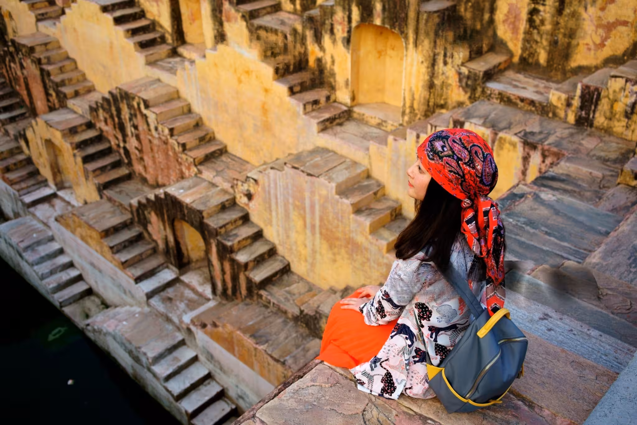 Ancient Chand Baori stepwell in Abhaneri, Rajasthan, featuring symmetrical geometric staircases descending into a deep historic water reservoir.